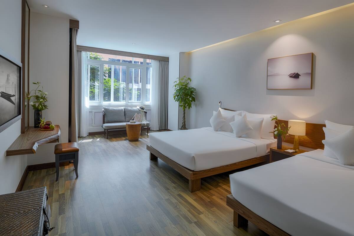 Een moderne hotelkamer met een groot bed, een bank, een bureau en een raam met gordijnen.