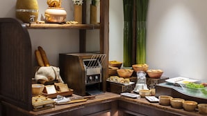 Una cocina con armarios de madera, una cafetera y diferentes tazones y utensilios.