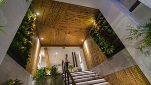 Una escalera moderna con paneles de madera y plantas.