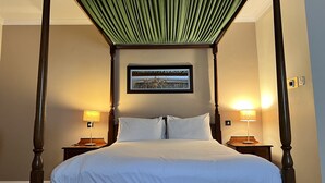 A four-poster bed with a green canopy, two bedside lamps, and a framed picture on the wall. - Brook Mollington Banastre Hotel and Spa (Chester)