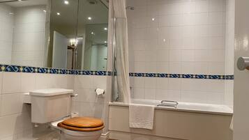 A bathroom with a toilet, a shower with a glass door, and a bathtub.