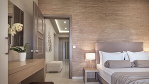 A modern bedroom with a large bed, bedside table, and a potted plant. - Koukounaria Hotel & Suites (Zakynthos)