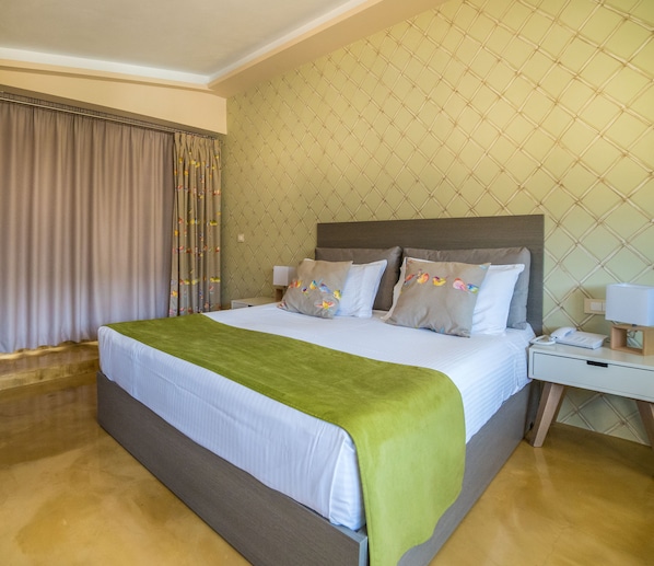 A hotel room with a bed, curtains, a nightstand, and a wall with a geometric pattern.