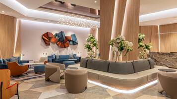 A modern lobby with a curved seating area, a geometric wall art piece, and a wooden accent wall.