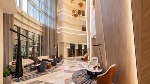 A spacious lobby with a modern design, featuring a mix of seating areas and a large, curved wall. - Sheraton Mall of the Emirates Hotel, Dubai (Dubai)
