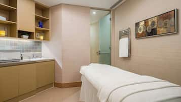 A modern bathroom with a towel-covered bench, a sink, and a shower area.