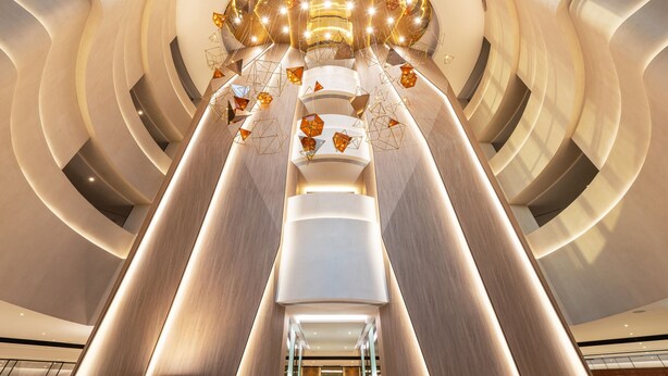 A modern interior with a central cylindrical structure, curved walls, and a series of lights. - Sheraton Mall of the Emirates Hotel, Dubai (Dubai)