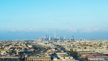 A cityscape with a prominent skyscraper, wide roads, and a mix of commercial and residential buildings.