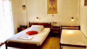 Un dormitorio con una cama individual, dos mesitas de noche y un tapiz en la pared.