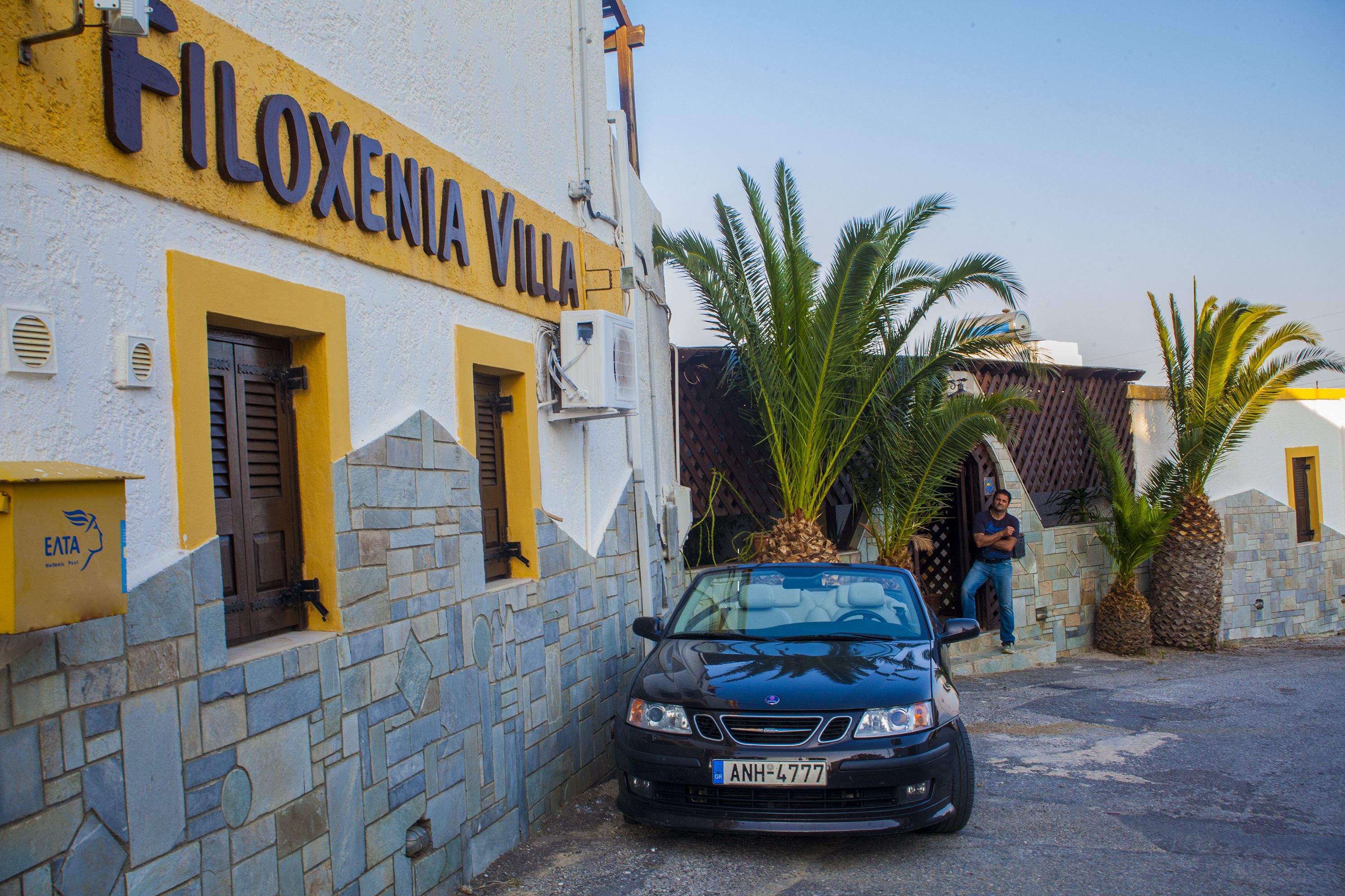 Un bâtiment appelé FILOXENIA VILLA, avec des murs en pierre et des touches de couleur jaune.