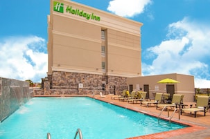 Un hotel Holiday Inn con piscina y tumbonas.