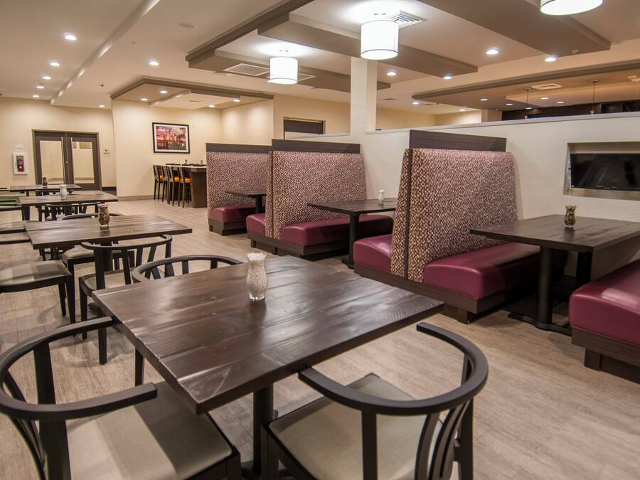 Un restaurante con cabinas y mesas, algunas con asientos acolchados.