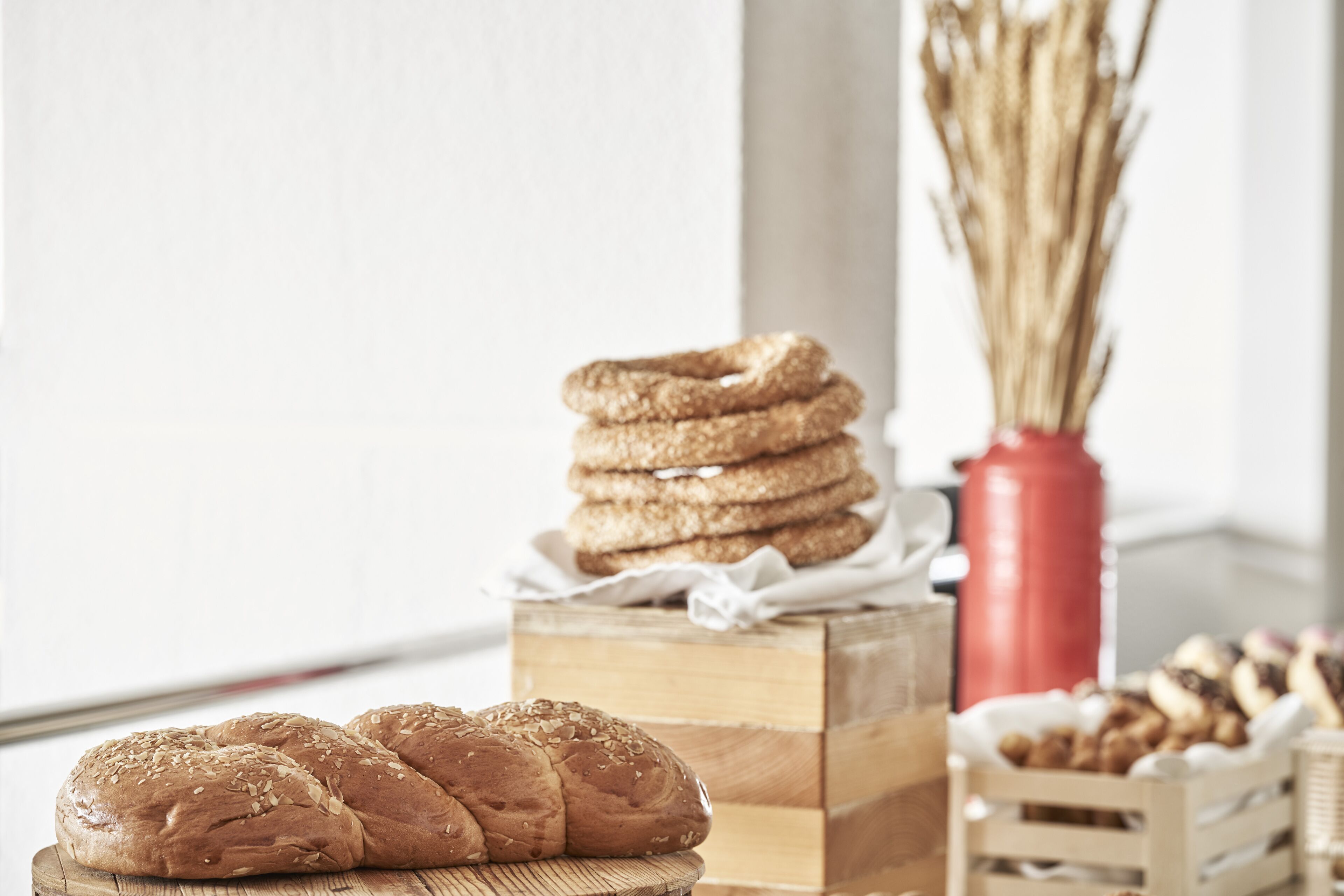 A wooden table with a loaf of bread and a stack of cookies.