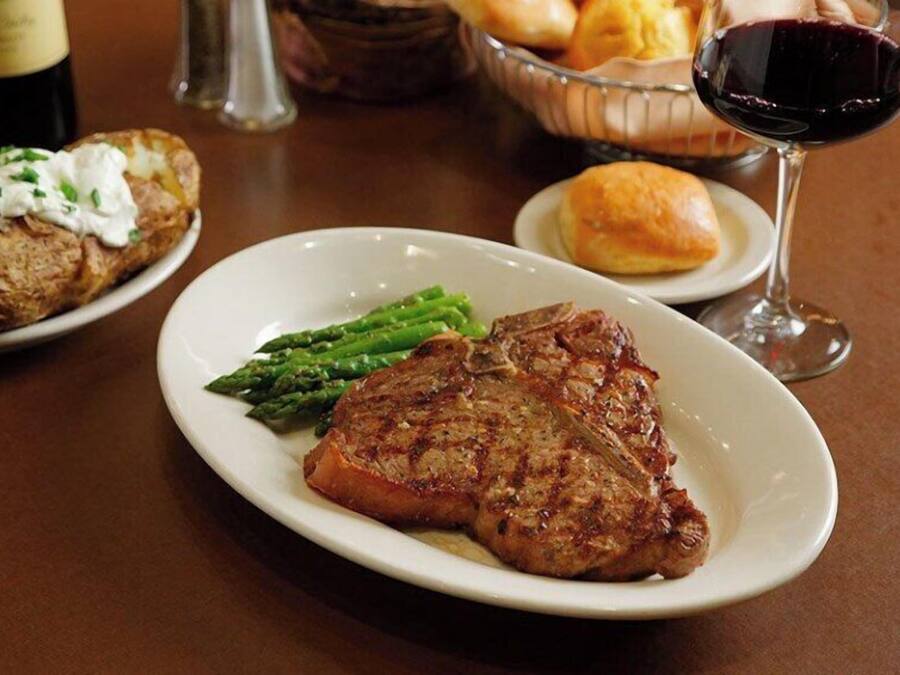 A plate with a steak, asparagus, and a side of potatoes.