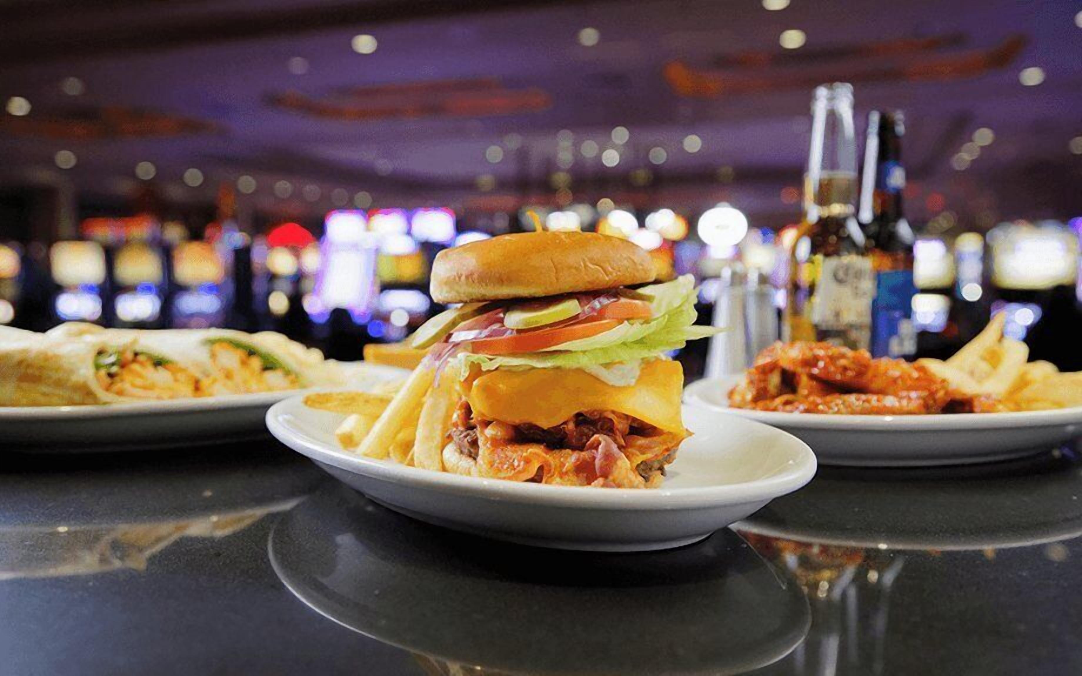 Un restaurante con una hamburguesa, papas fritas y una bebida sobre la mesa.
