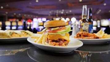 Un restaurante con una hamburguesa, papas fritas y una bebida sobre la mesa.