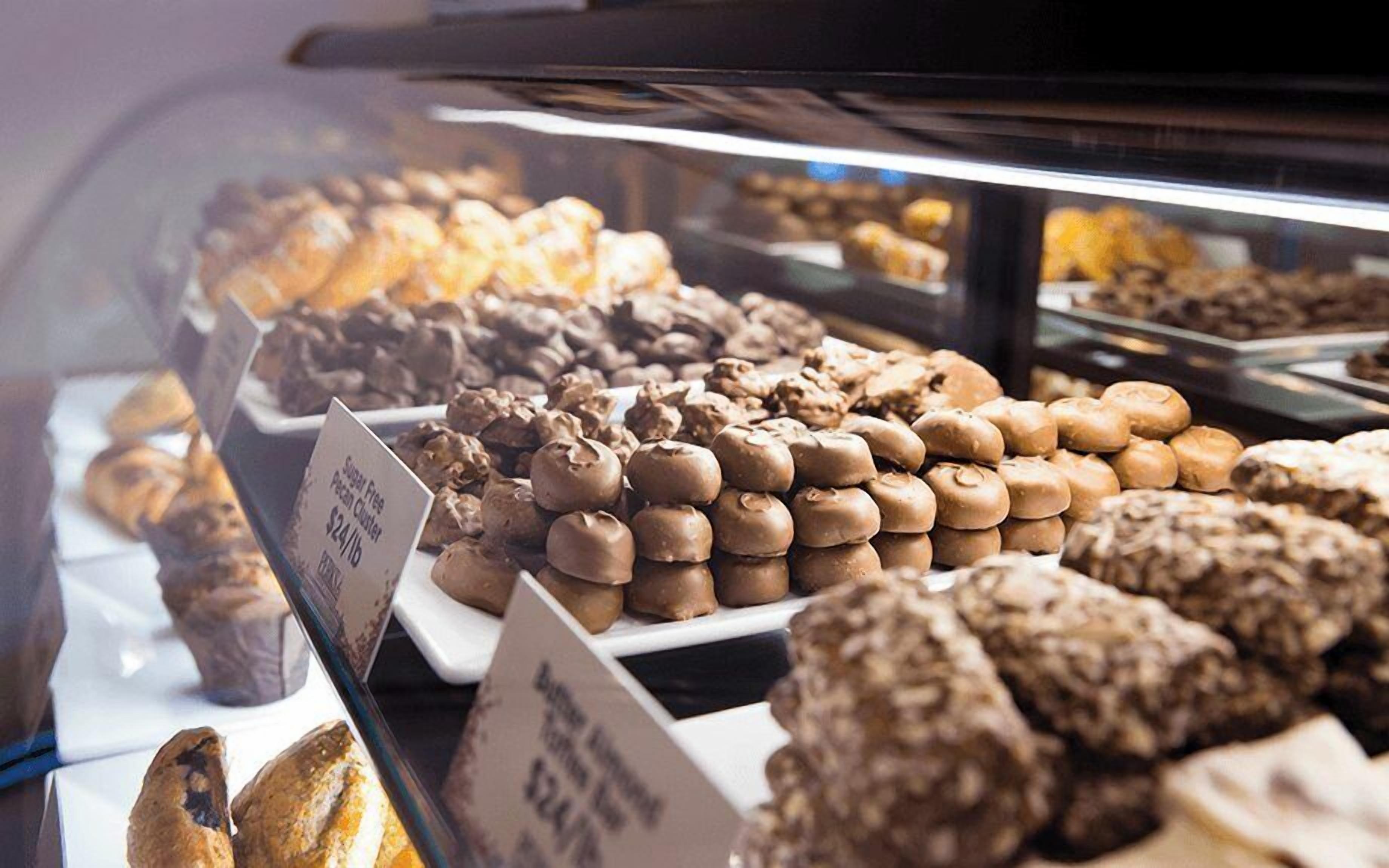 Een bakkerij vitrine met diverse gebakjes, waaronder chocolade producten en patisserie.