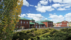 A brick building with green roofs and a parking lot.