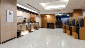 A hotel reception area with a clean, modern design, featuring a reception desk, seating area, and a sign for the Roynet Hotel. - Daiwa Roynet Hotel Hakata - Gion (Fukuoka)
