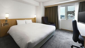 A hotel room with a large bed, a desk, a chair, a TV, and a window with curtains. - Daiwa Roynet Hotel Hakata - Gion (Fukuoka)