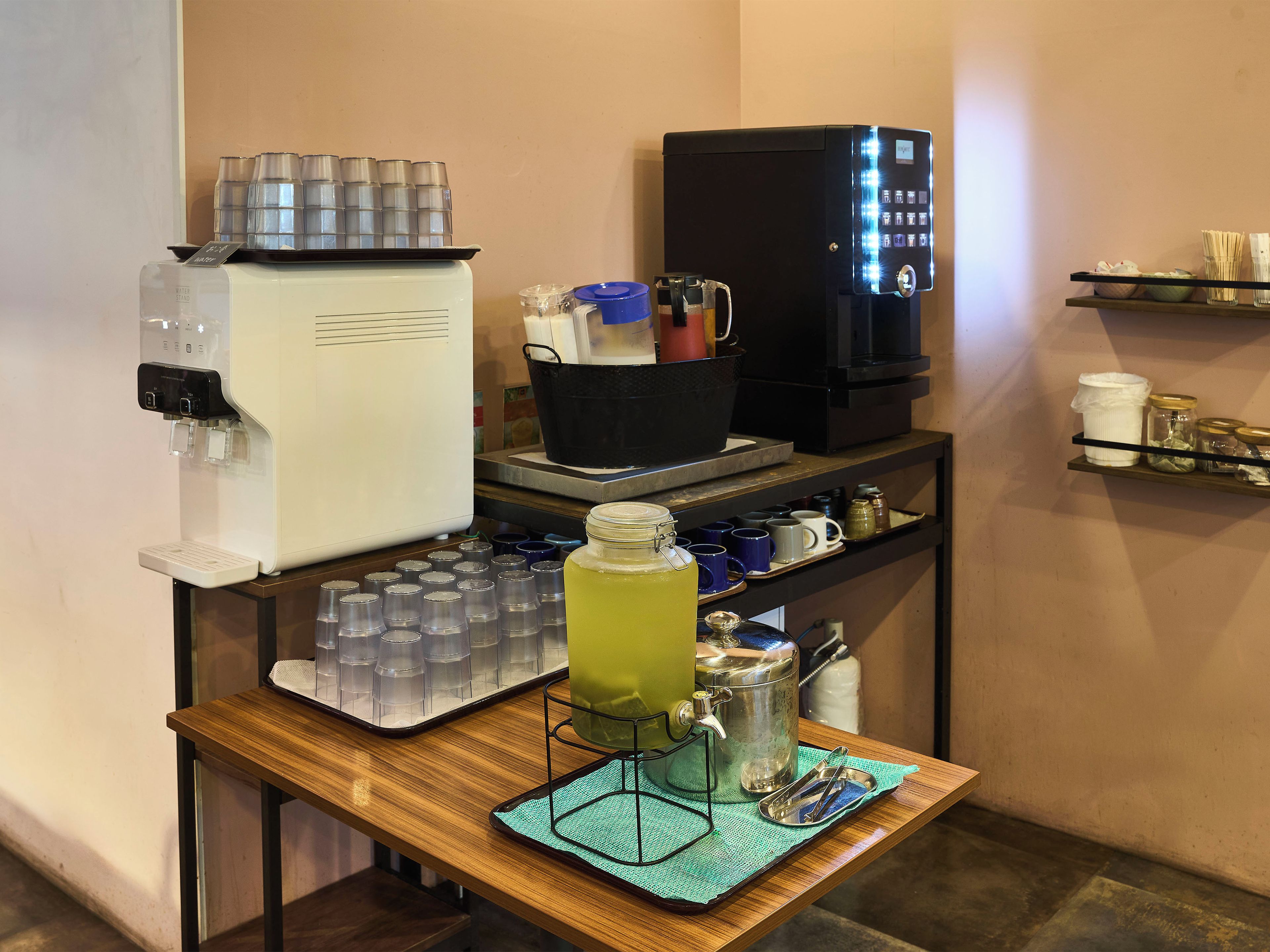 A coffee station with a coffee machine, a water dispenser, and a mug rack.
