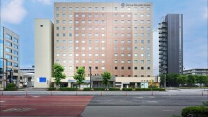 Un hotel con fachada moderna, varios pisos y un letrero llamativo.