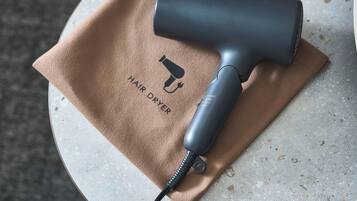 A hair dryer on a beige cloth with the text 'HAIR DRYER' and a logo.