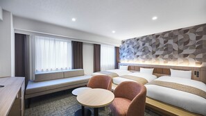 Una habitación de hotel con una cama, un área de estar con una mesa y una pared con diseño geométrico.