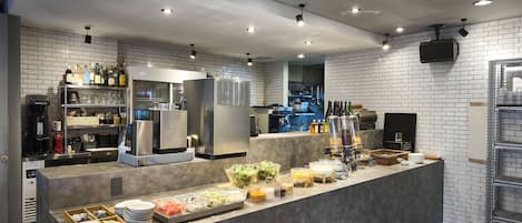 Une cuisine moderne dotée d’un îlot central, équipé de divers appareils et aménagé avec un espace buffet.