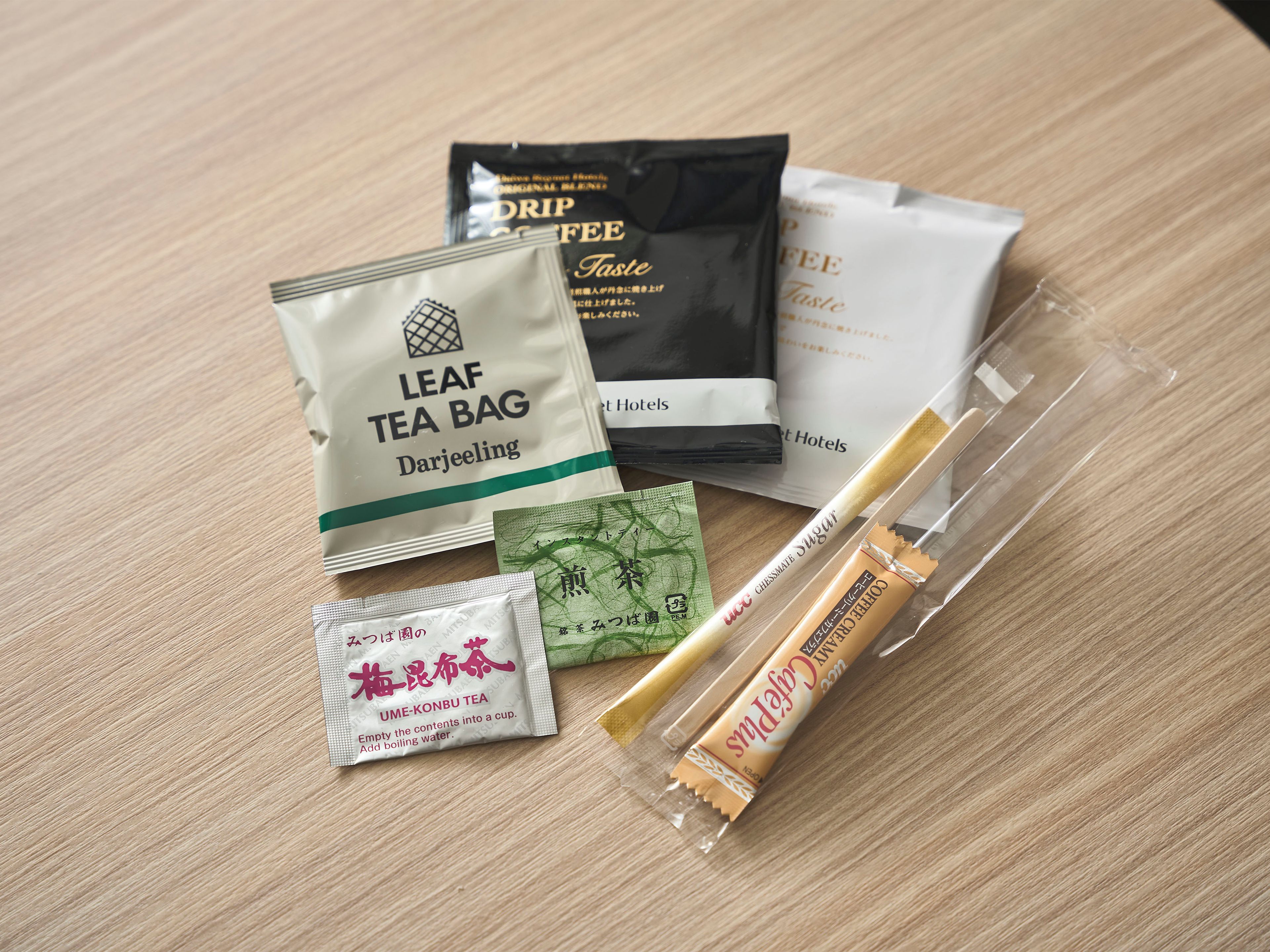 A variety of tea bags and a leaf tea bag on a wooden surface.
