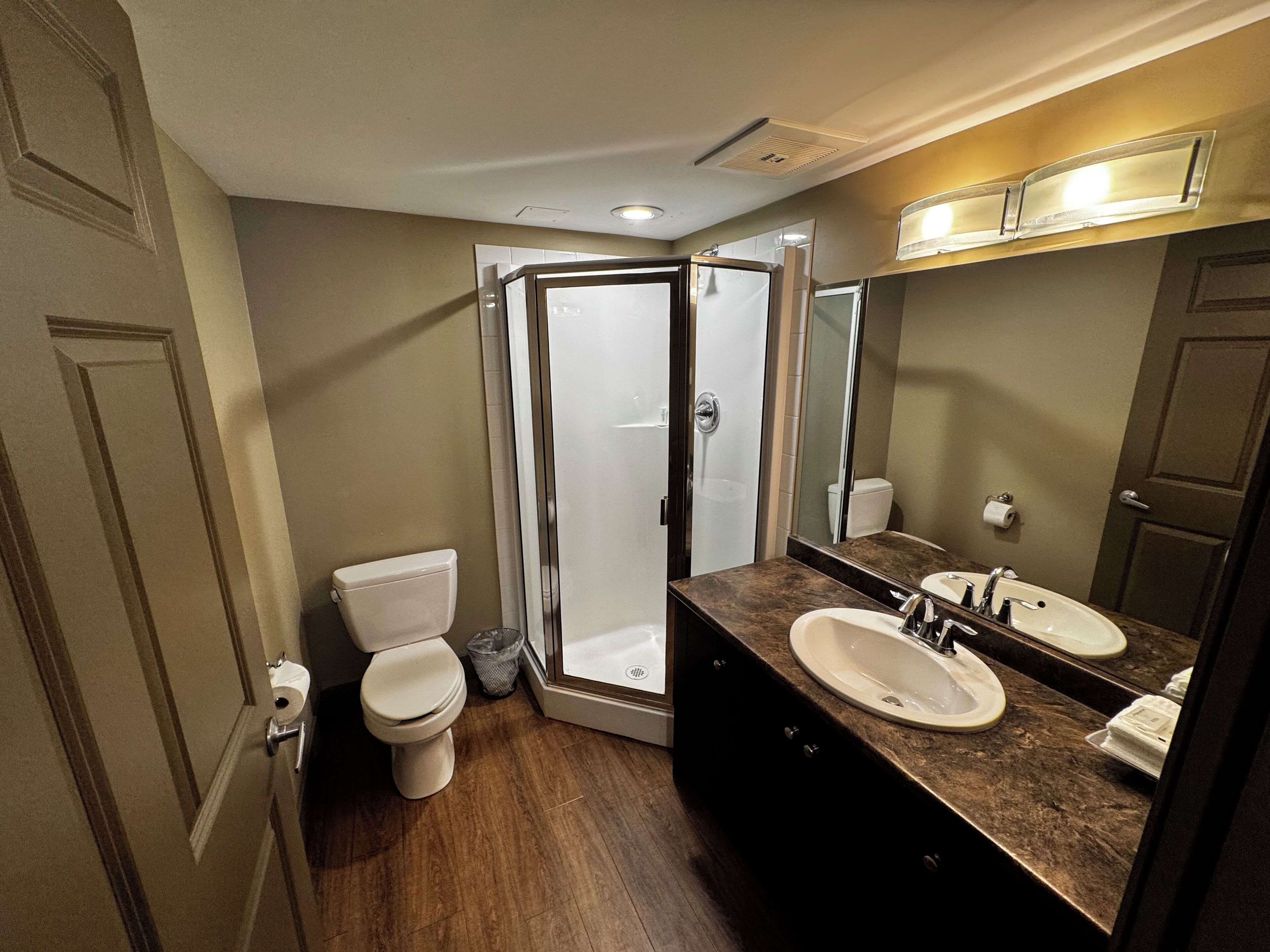 A bathroom with a shower, toilet, and sink.
