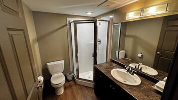 A bathroom with a shower, toilet, and sink.