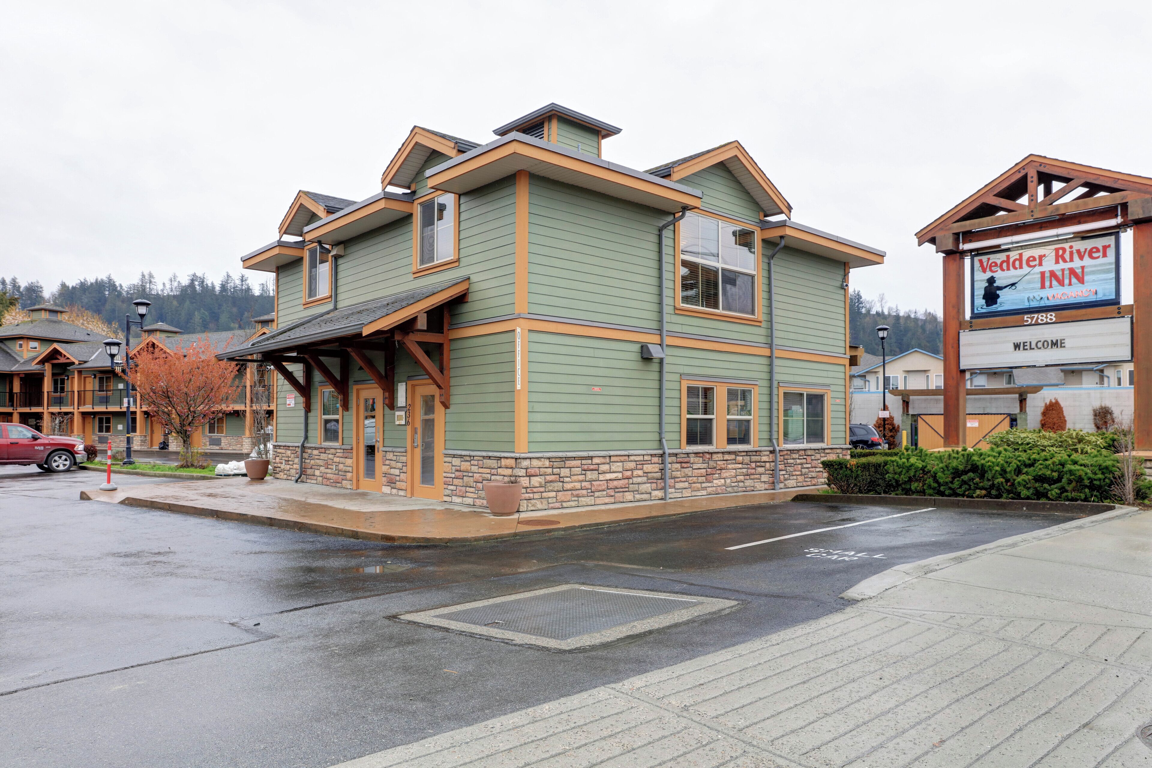 A two-story building with a green facade and a sign for Vedder River Inn.