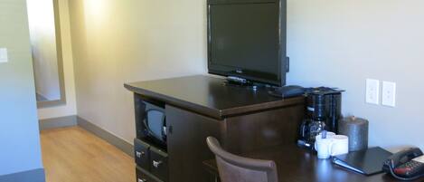 A small office space with a desk, chair, and a flat-screen TV.