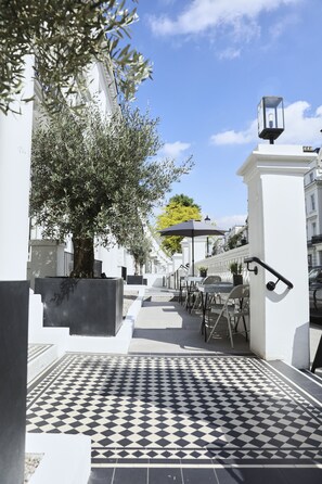 A pathway lined with outdoor seating and a patterned tile floor.