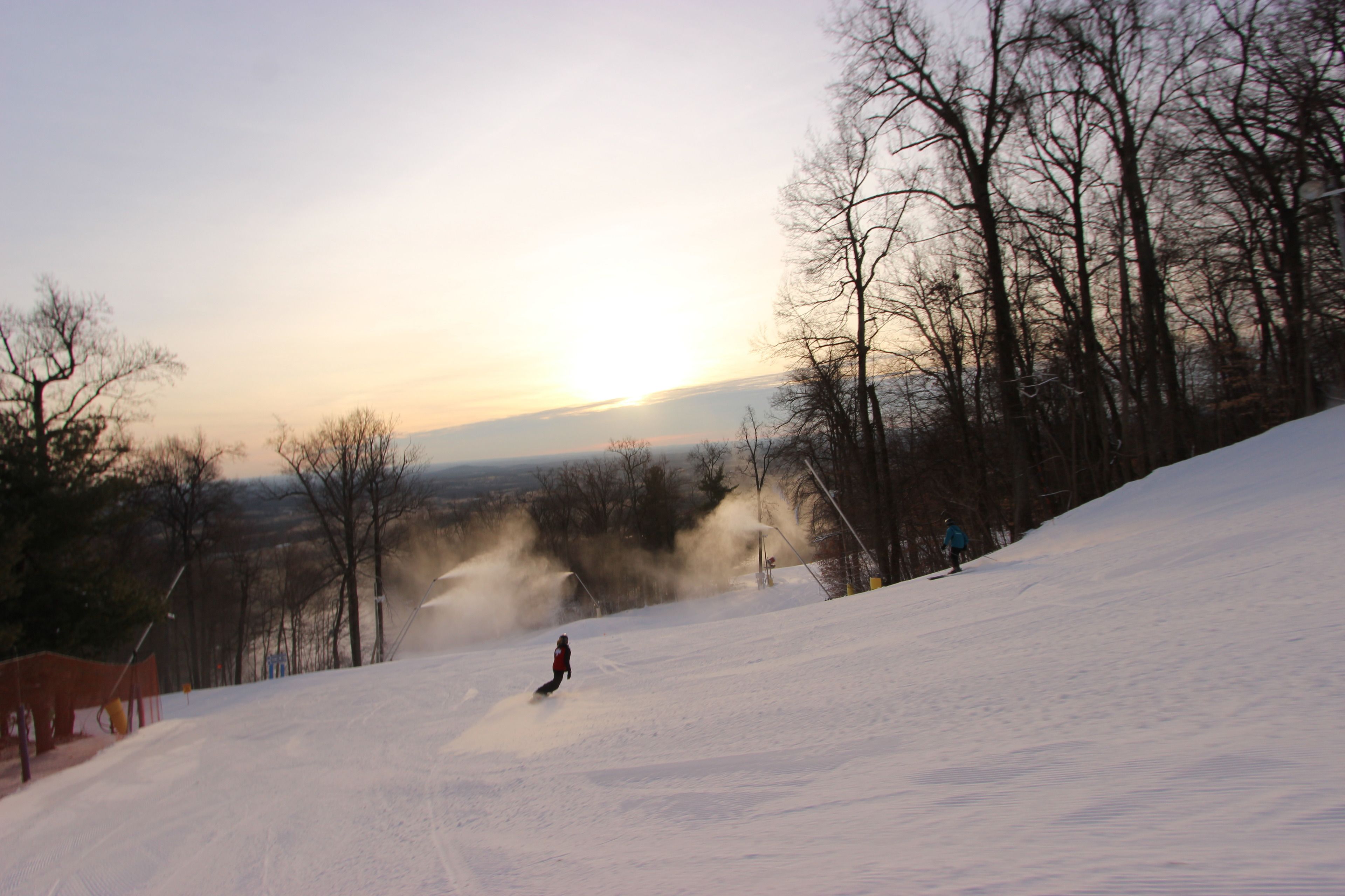 A snowy slope with a person skiing down.