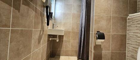 Un baño con lavabo, inodoro y cortina de ducha.
