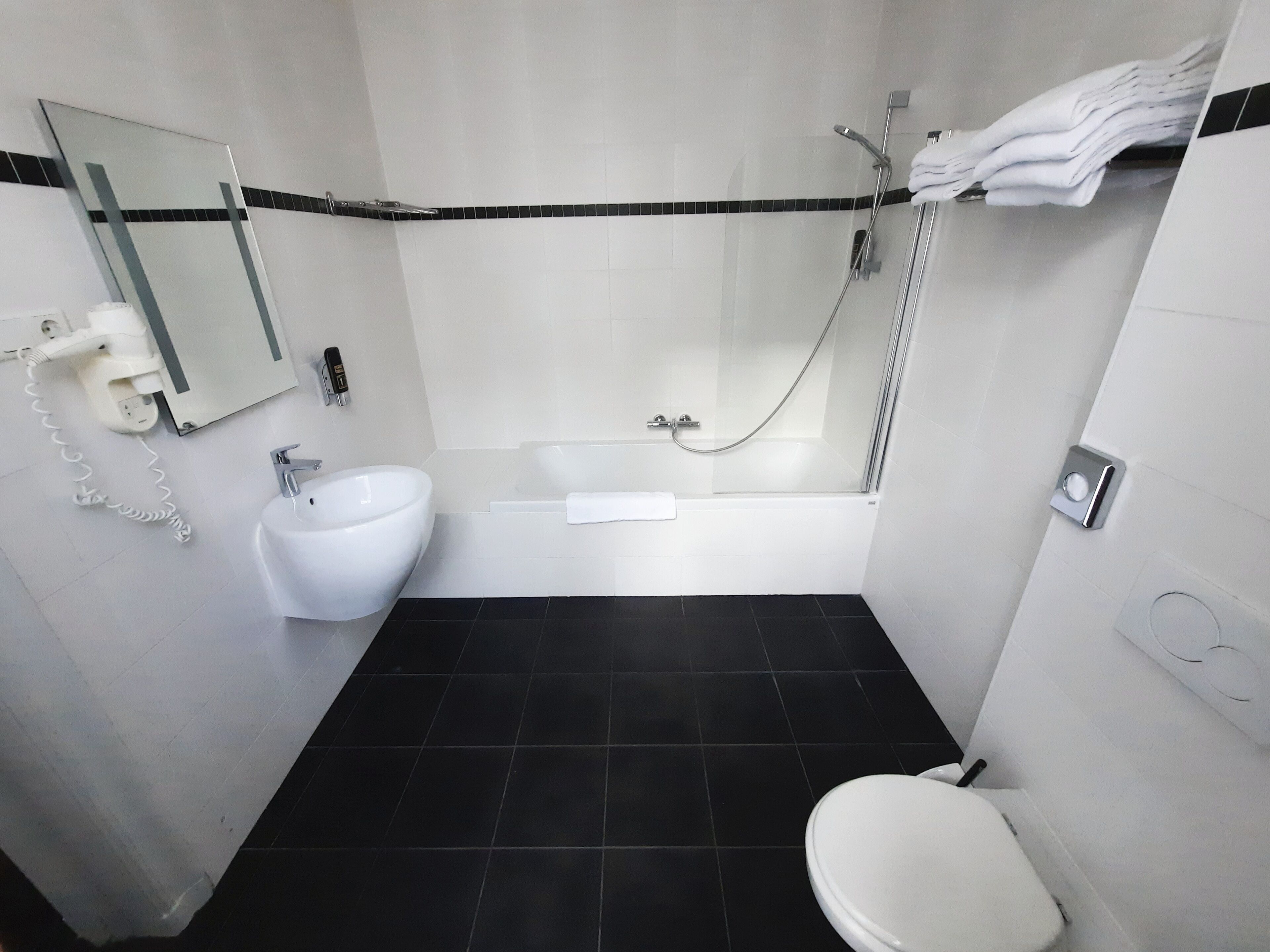 Een moderne badkamer met een bad, wastafel en toilet.