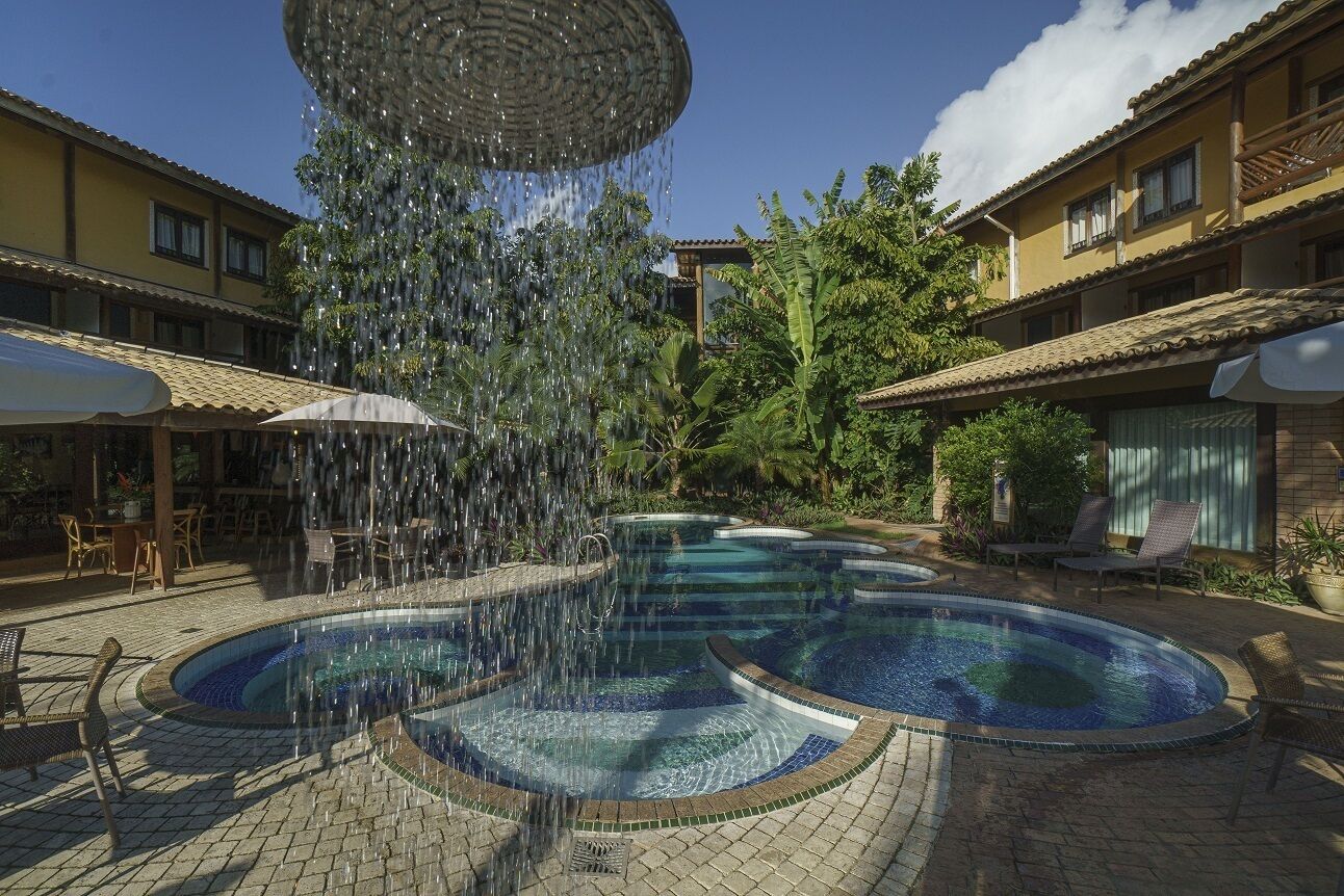 Una piscina al aire libre, sombrillas, tumbonas