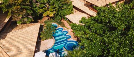 Un resort con piscina, paneles solares y abundante vegetación.