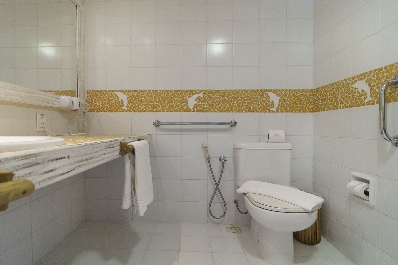 A bathroom with a toilet, shower, and a towel rack.