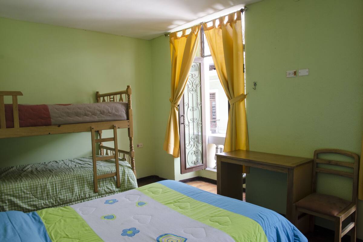 Una habitación con literas, un escritorio y una silla.