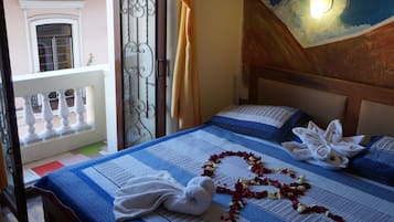 A hotel room with a bed, a balcony, and a decorative wall.
