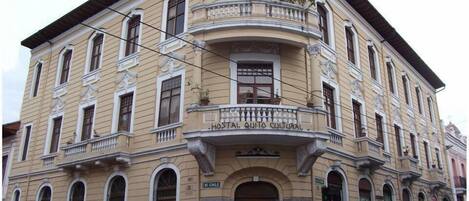 A historic building with a balcony and a sign reading "Hostal Quito Cultural".