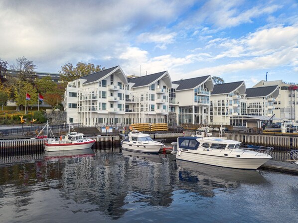 A marina with several boats docked, surrounded by modern multi-story buildings with balconies. - Molde Fjordhotell - by Classic Norway Hotels (Molde)