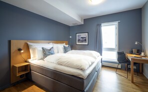 A modern bedroom with a large bed, a desk with a chair, and a window with curtains. - Molde Fjordhotell - by Classic Norway Hotels (Molde)