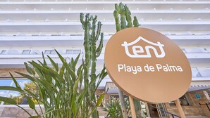 Letrero de Playa de Palma con un edificio moderno al fondo.