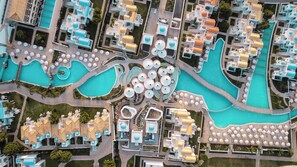 Vue aérienne d’un complexe hôtelier doté de plusieurs piscines, de parasols et de bâtiments.
