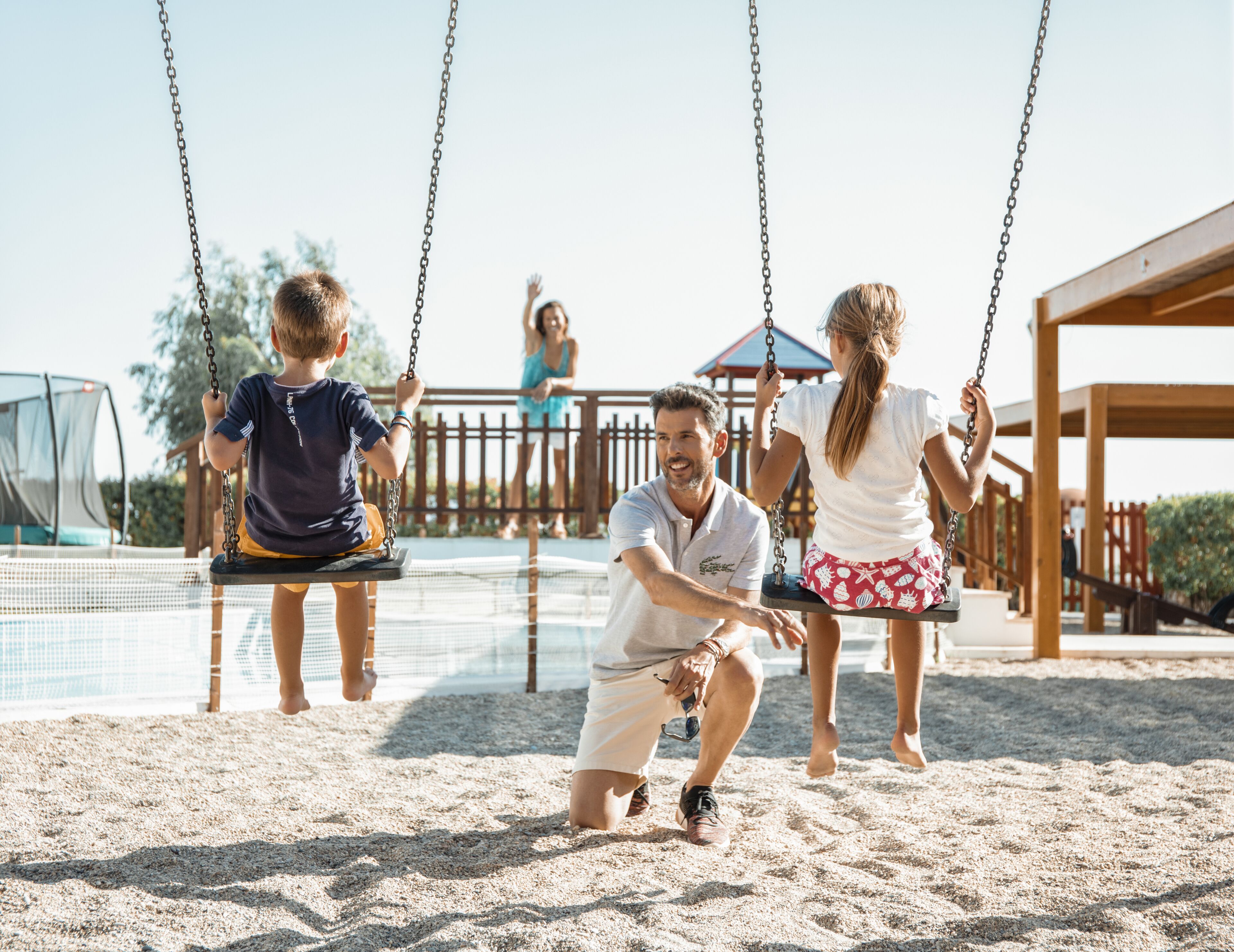 A playground with swings and a netted area.