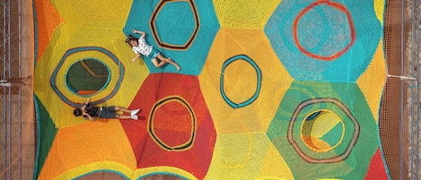 A colorful, geometric-patterned netted structure with circular designs, likely a playground or play area.